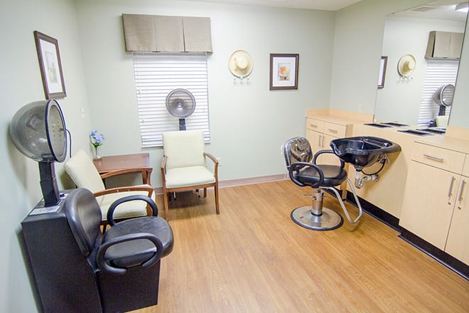 An interior view of a hair salon with multiple chairs and a hair styling station.