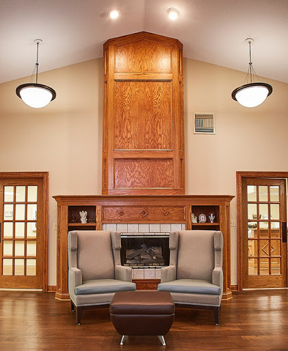 A cozy living room featuring a stylish seating arrangement and elegant wood paneling around a fireplace.