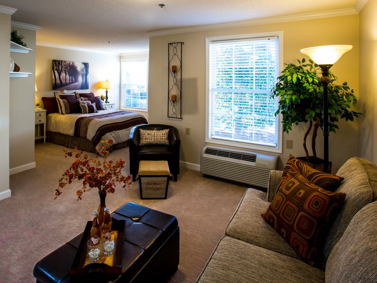 A cozy bedroom with a connected living area, featuring comfortable furniture and warm lighting.