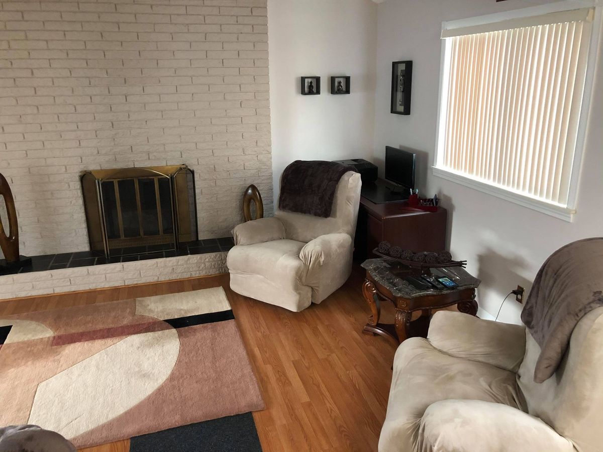 A cozy living room with a fireplace and armchairs.