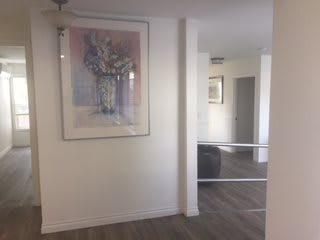 A modern hallway featuring framed artwork and a large mirror.