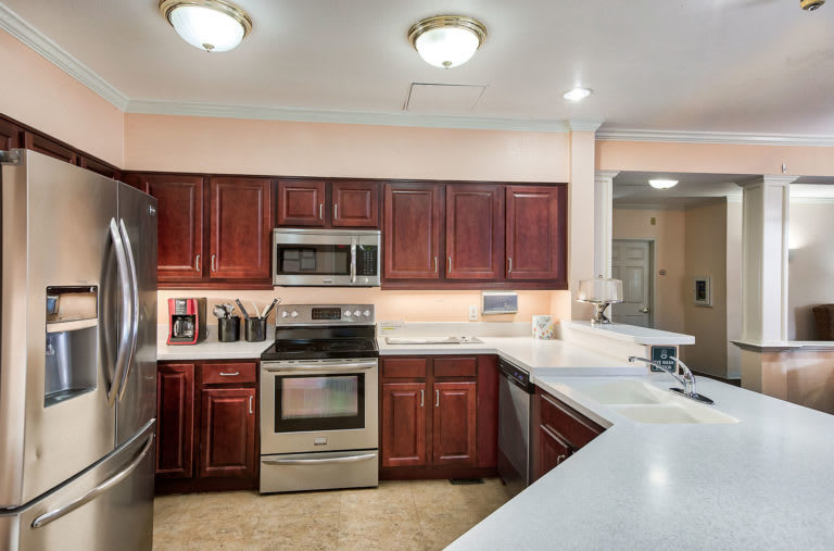 A modern kitchen with stainless steel appliances and wooden cabinetry.