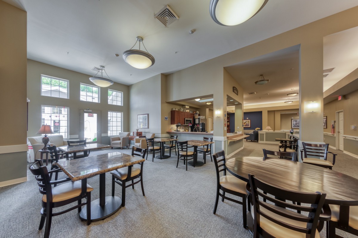 A spacious cafe interior with modern furnishings and ample natural light.