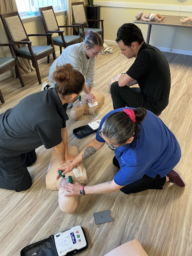 Participants engage in CPR training, practicing lifesaving techniques on a training dummy.