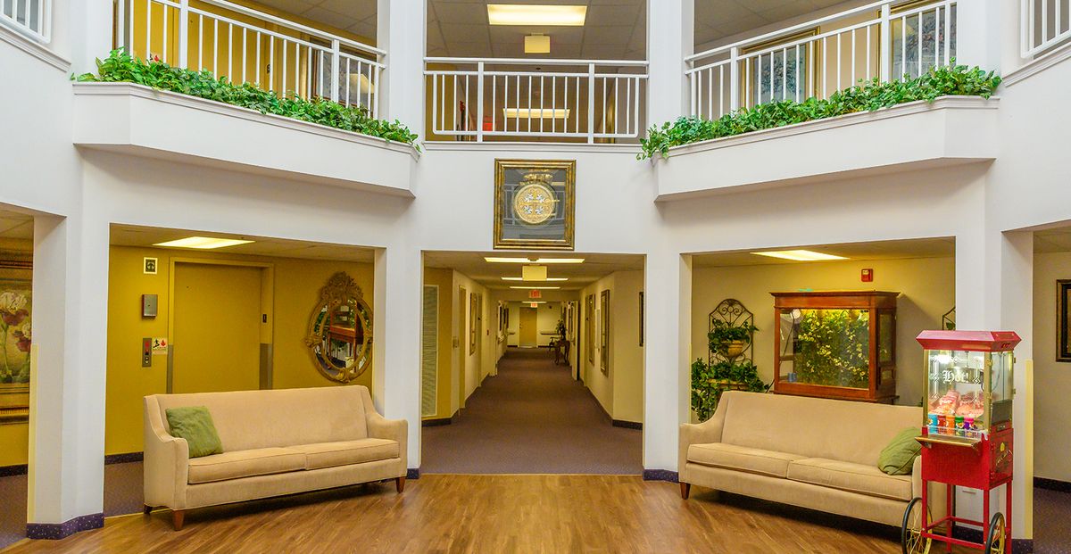 A well-lit lobby area with couches and a hallway leading to rooms.