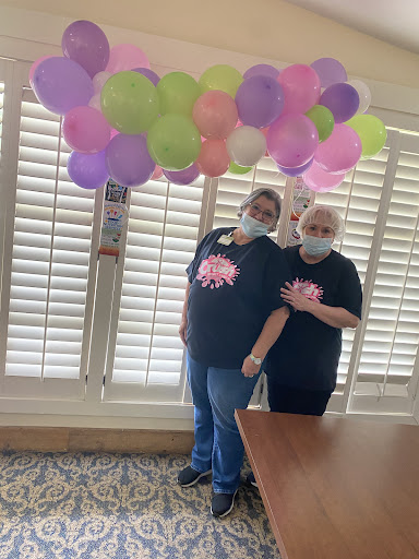 Two friends celebrating with colorful balloons