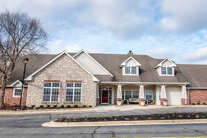 A suburban house with a stone facade and gabled roof.
