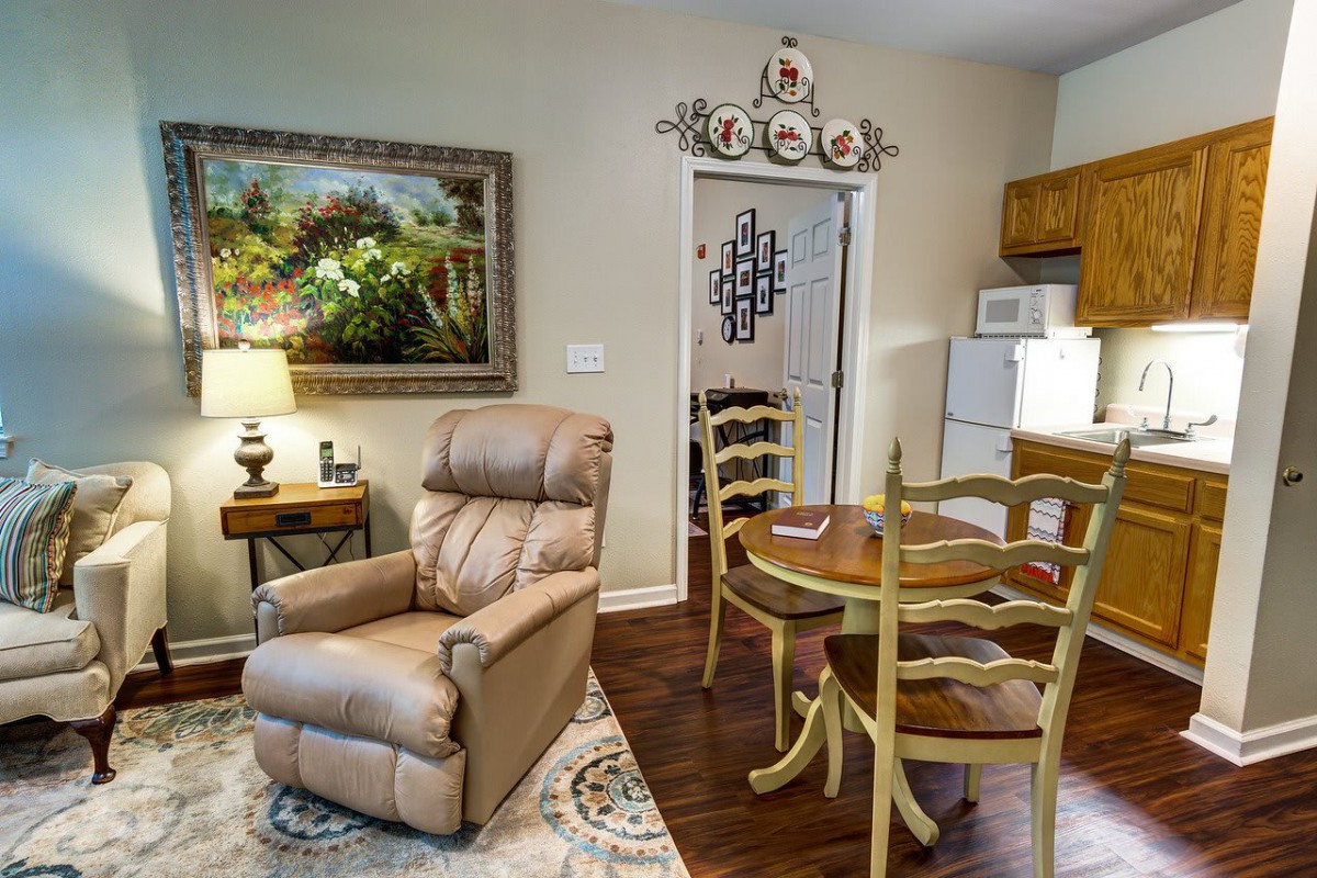 A cozy living space featuring a recliner and dining area with warm decor.