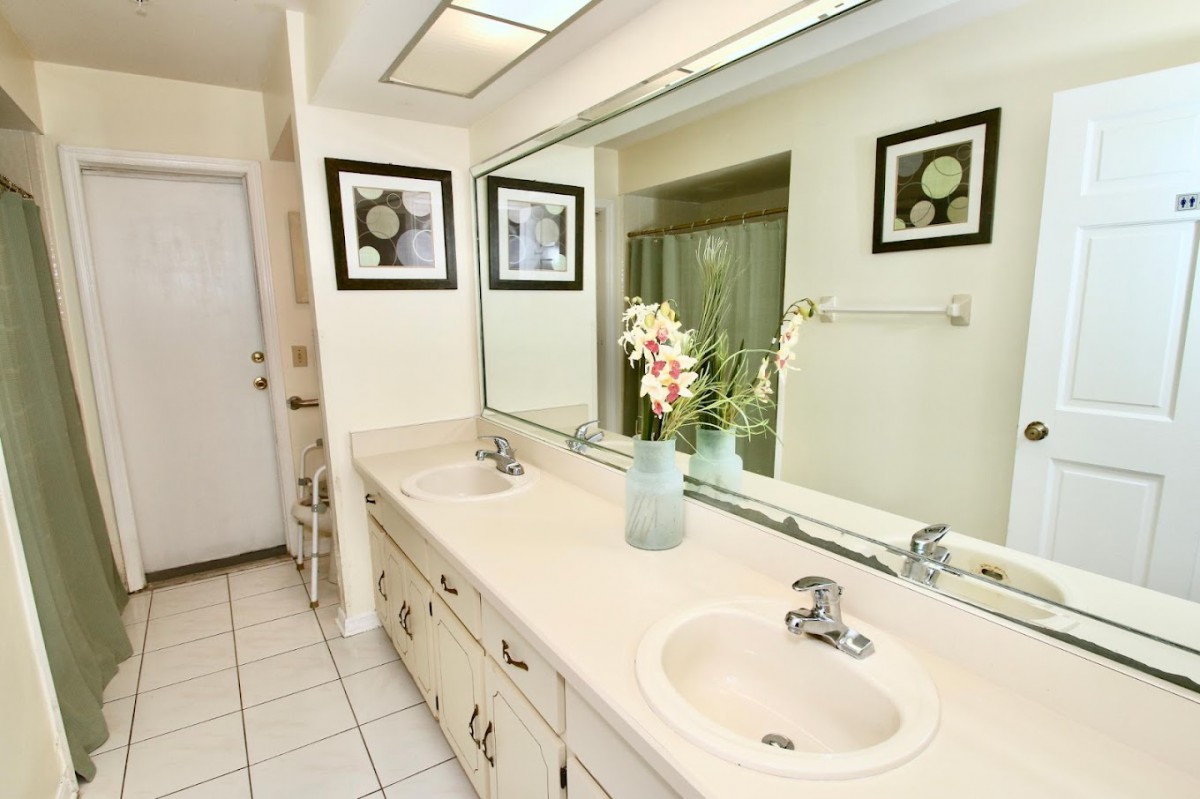 A modern bathroom featuring a double sink with a large mirror and elegant decor.