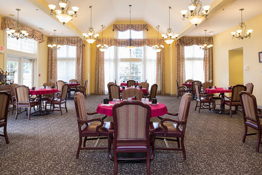 A well-lit dining room featuring elegantly set tables and comfortable seating.