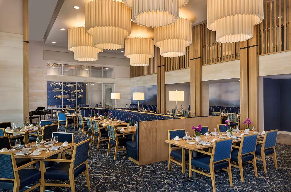 A modern restaurant interior with elegant lighting and neatly arranged tables.