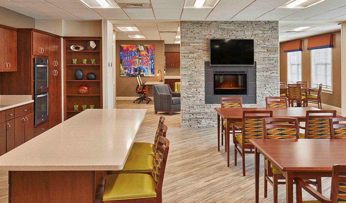 A modern lounge area featuring a dining setup, a fireplace, and a mounted television.