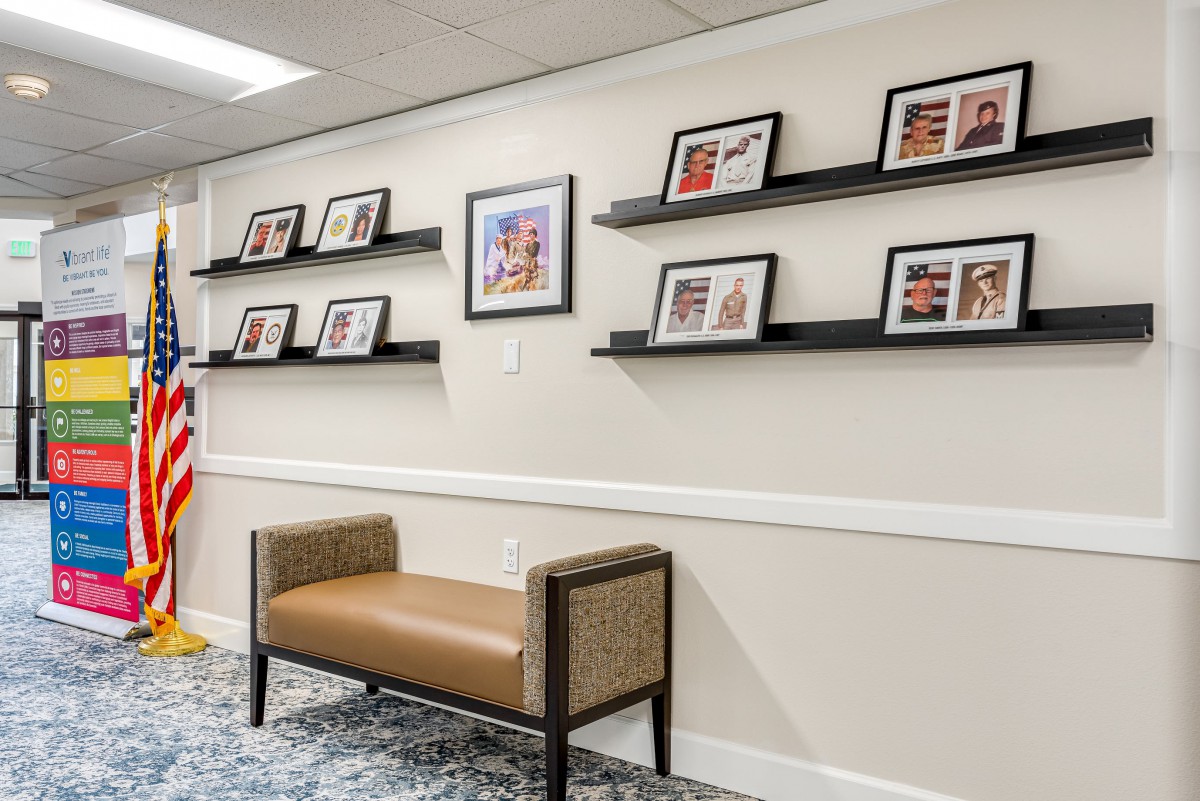 A cozy waiting area featuring a bench and a collection of framed photos on the wall.