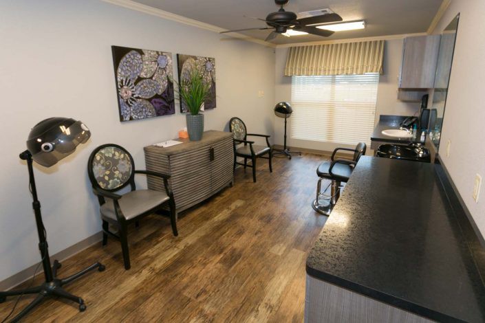 A modern waiting room with chairs, artwork, and a wooden floor.