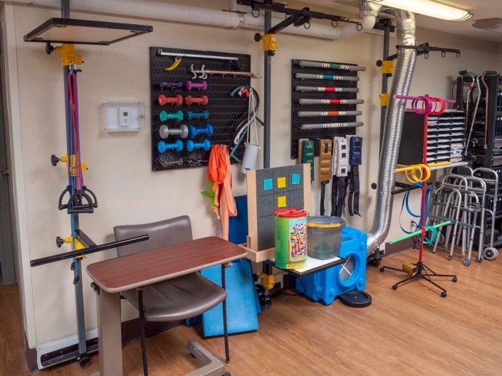 A therapy room equipped with various rehabilitation and sensory tools for occupational therapy.