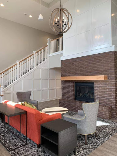 A modern living room featuring a cozy fireplace, elegant furniture, and a stylish staircase.