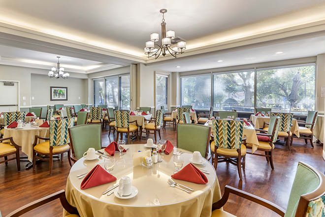 An elegant dining room with neatly arranged tables and chairs, featuring a sophisticated interior design.