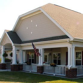 A suburban house with a front porch and an American flag.