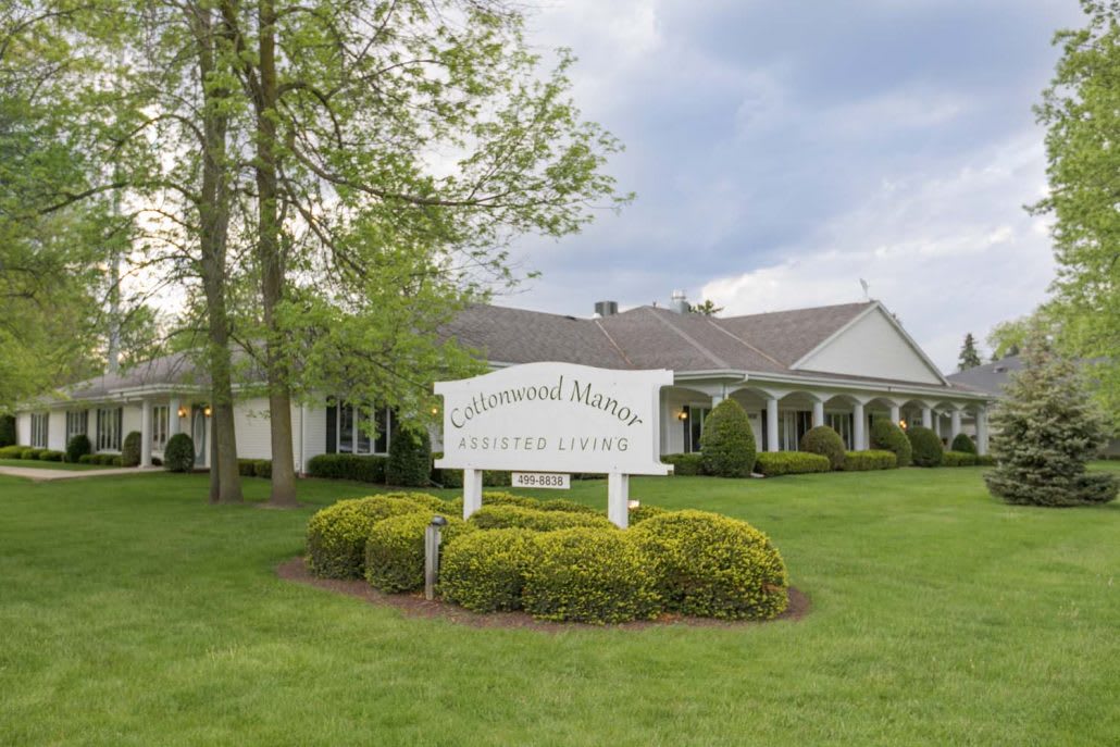 A funeral home with a well-maintained lawn and a sign at the front.