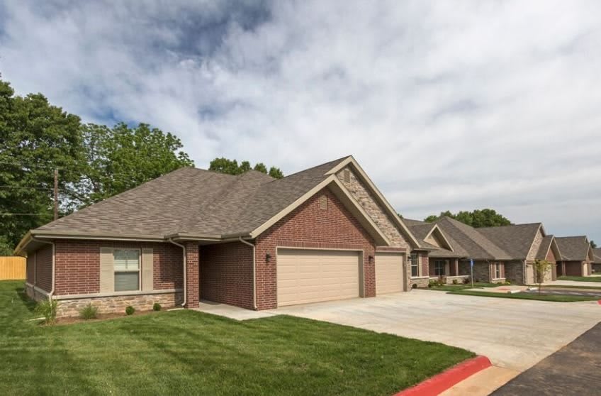 A suburban house with a two-car garage and well-maintained lawn.