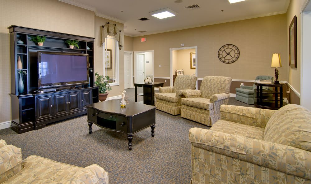 A comfortable living room with plush chairs and a large television.