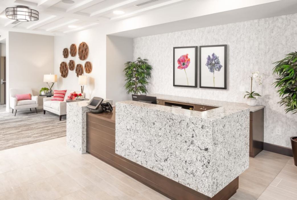 A modern reception area featuring a stylish desk, decorative artwork, and comfortable seating.