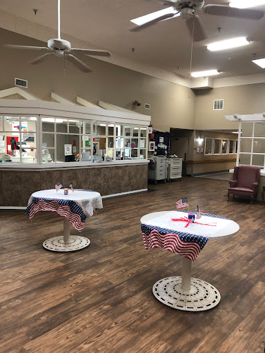 A cozy community center space featuring tables dressed with decorative tablecloths and a welcoming atmosphere.