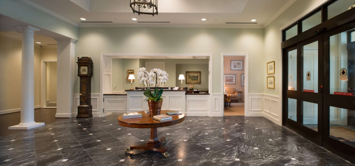 Elegant lobby area with a central table displaying orchids and ambient lighting.