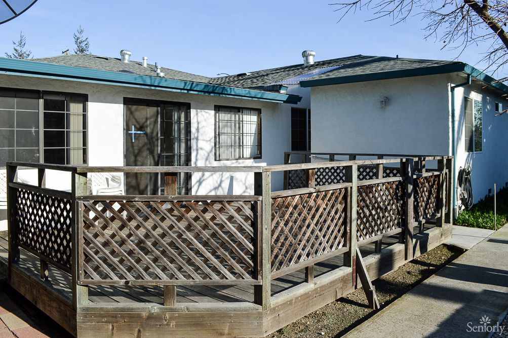 A single-story house with a wooden ramp and lattice fence.