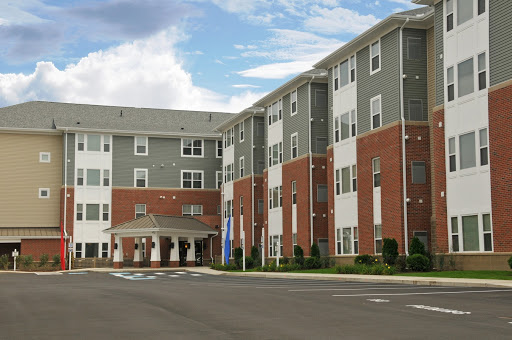 A modern multifamily residential building with a blend of brick and siding.
