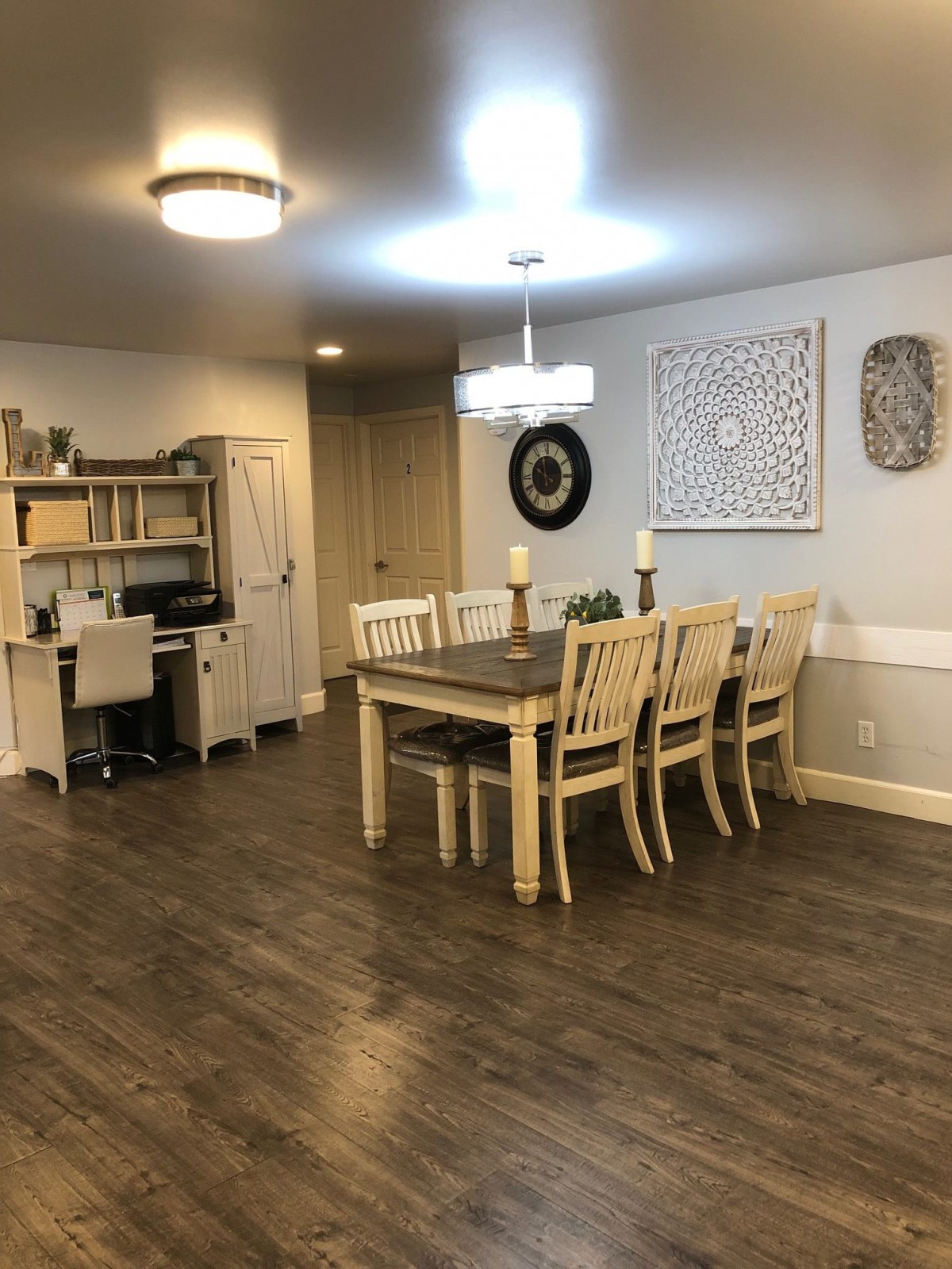 A cozy dining room with a wooden table, chairs, and an adjacent office space.