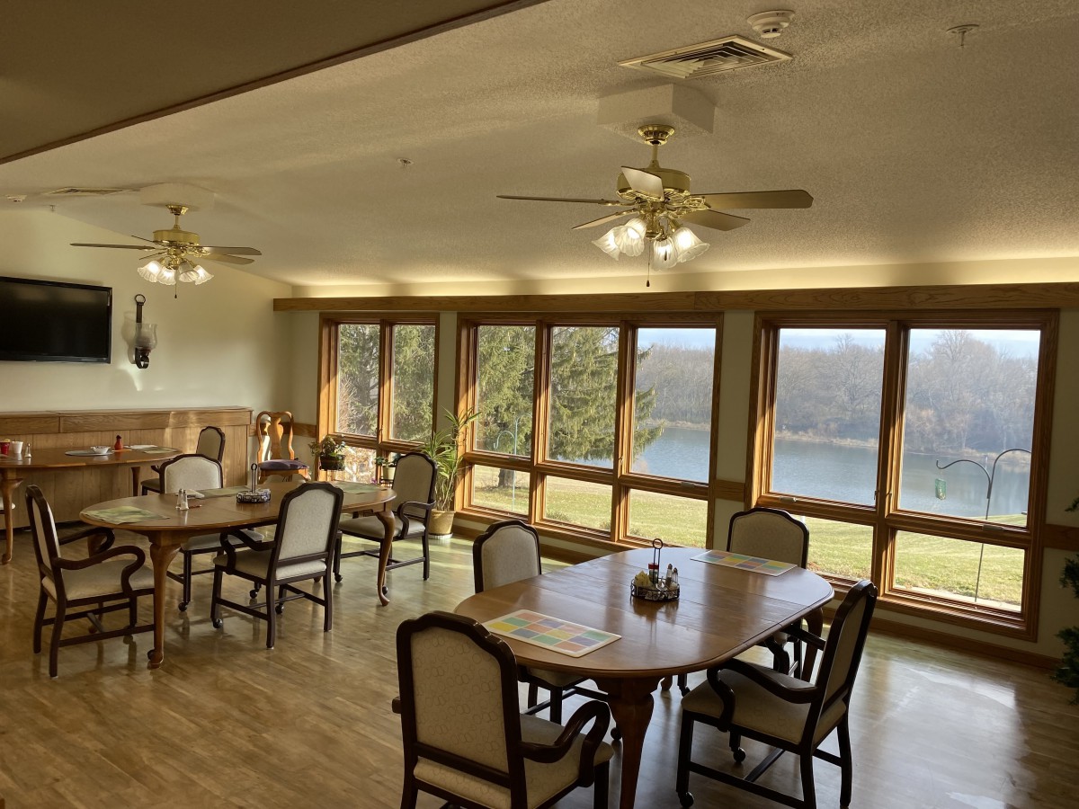 A cozy dining room with large windows offering a scenic lake view.