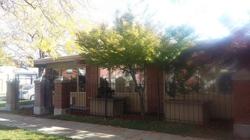 A charming residential house surrounded by greenery and a decorative fence.
