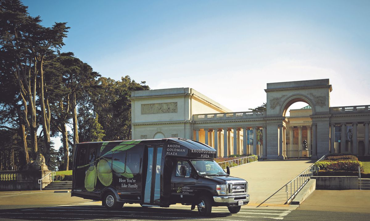 A truck parked in front of a monumental structure on a sunny day.