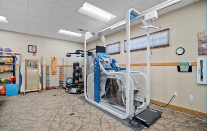 A modern rehabilitation and fitness machine in an exercise room.
