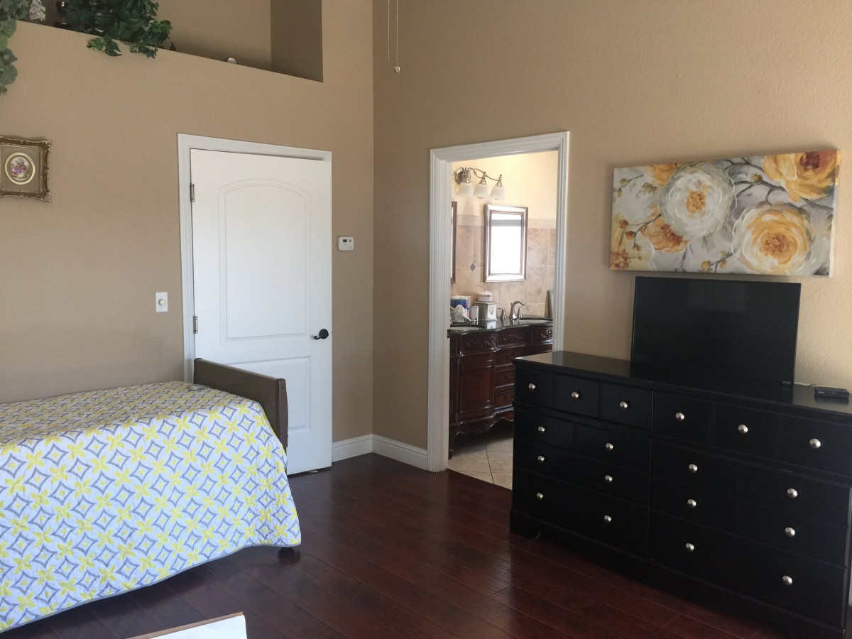 A cozy bedroom with a view into an adjoining bathroom.