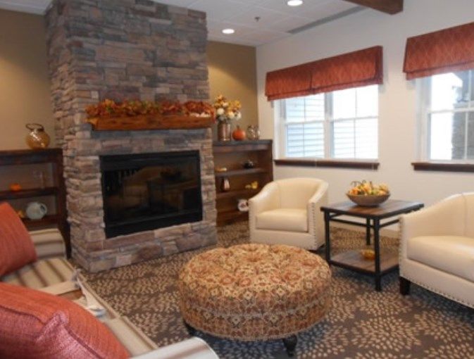 A cozy living room featuring a stone fireplace and comfortable seating.