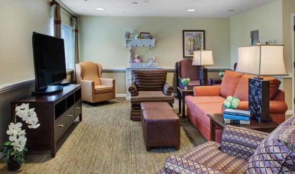 A cozy living room with comfortable seating, a television, and warm lighting.