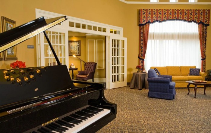 Elegant living room with a grand piano and comfortable seating.