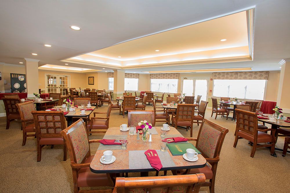 An elegantly set dining area with tables and chairs arranged neatly indoors.