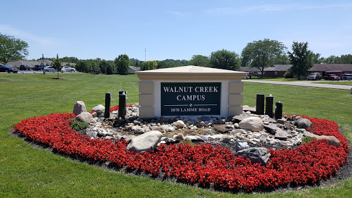 Entrance sign of Walnut Creek Campus surrounded by vibrant landscaping.
