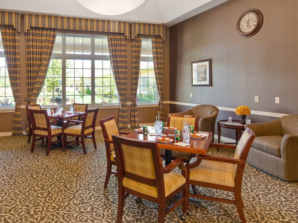 Elegant dining area with neatly arranged tables and chairs, featuring a large window and stylish decor.