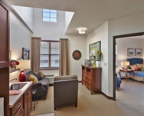 A cozy living room with a skylight, featuring comfortable seating and elegant decor.