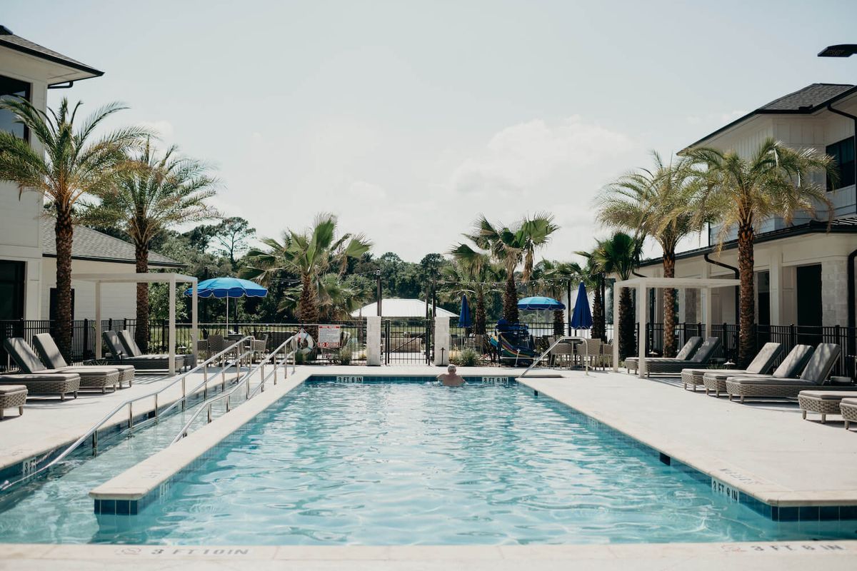 A serene outdoor pool surrounded by palm trees, perfect for a relaxing vacation.
