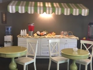 A cozy breakfast buffet setup with a variety of food items displayed under a striped awning.