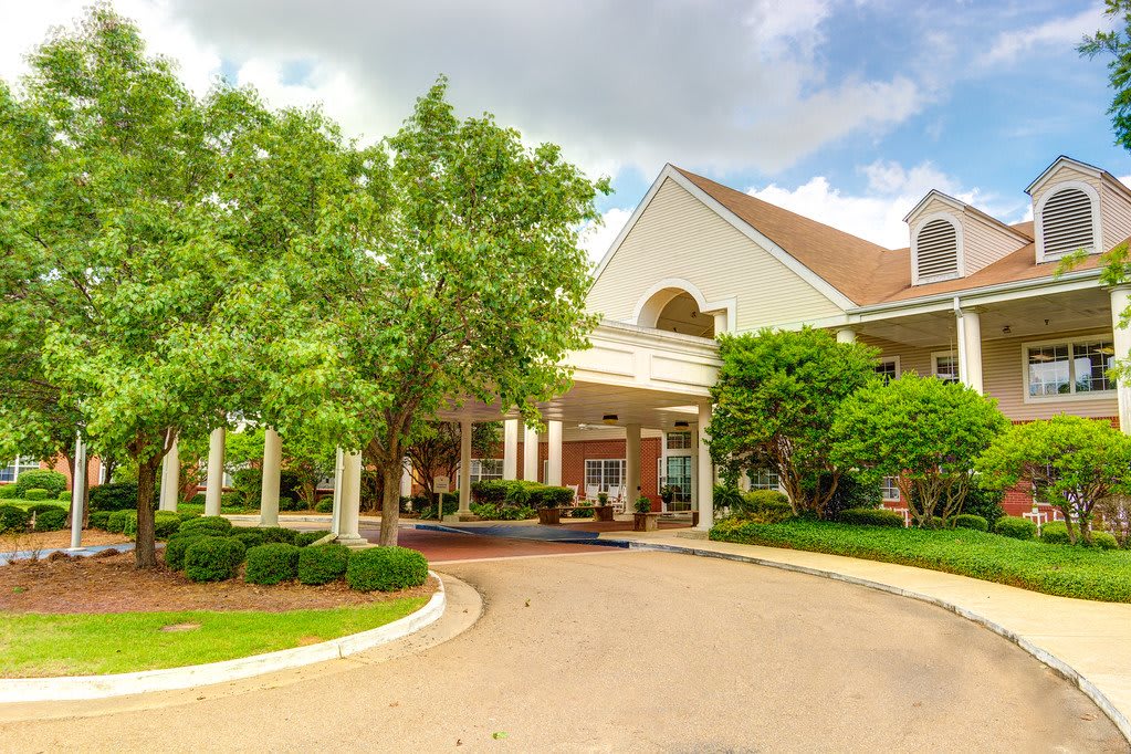 A suburban building with a landscaped entrance and a circular driveway.