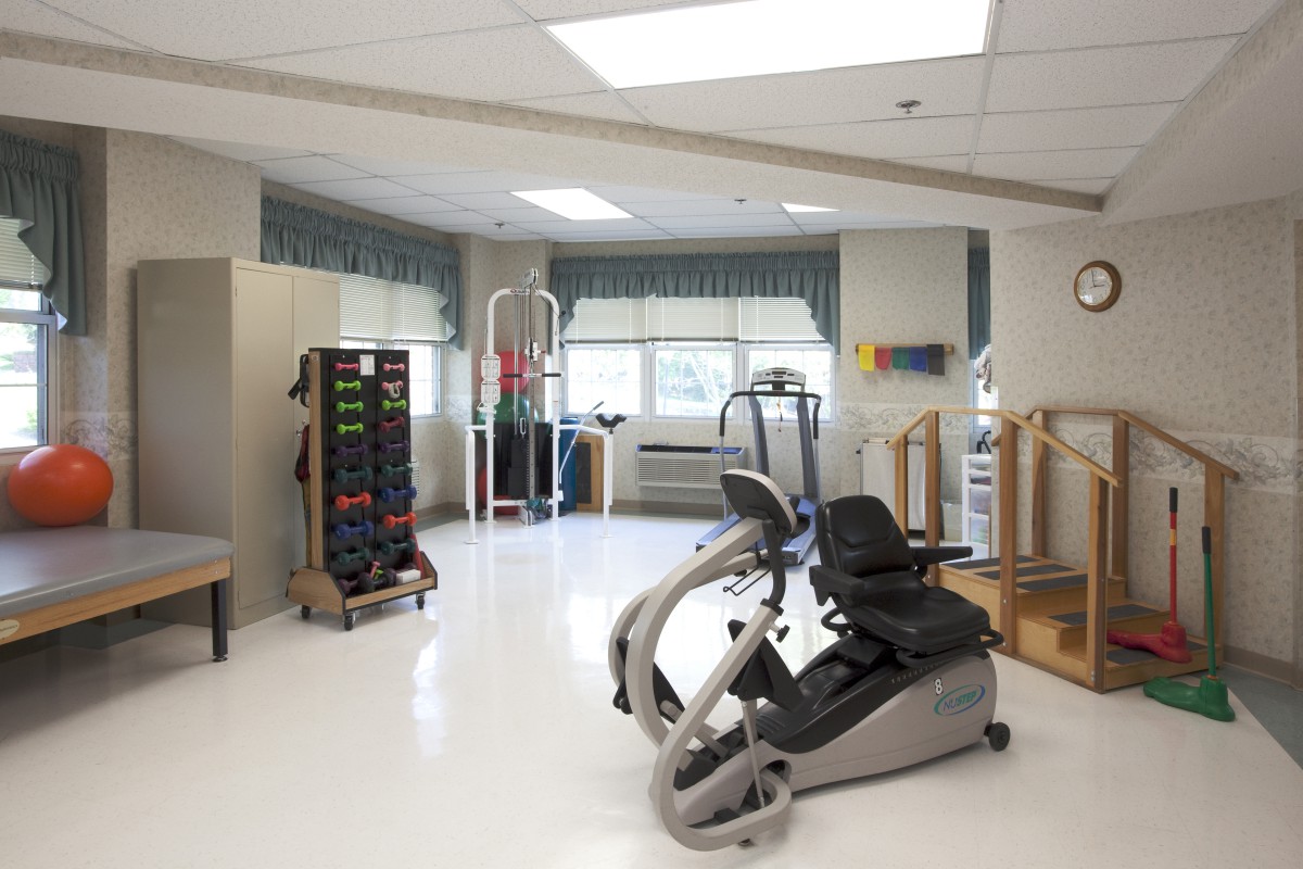 A physical therapy room equipped with various exercise machines and rehabilitation equipment.