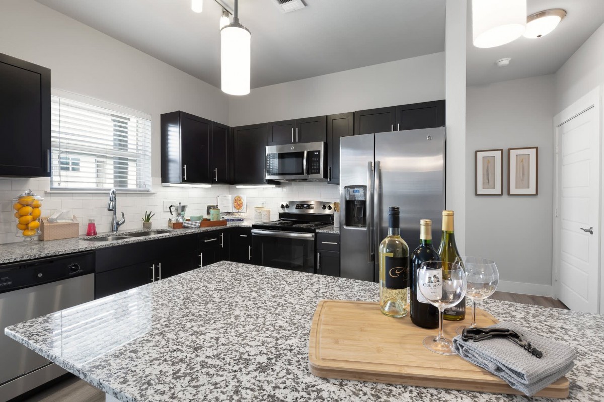 Modern kitchen with granite countertops and stainless steel appliances.
