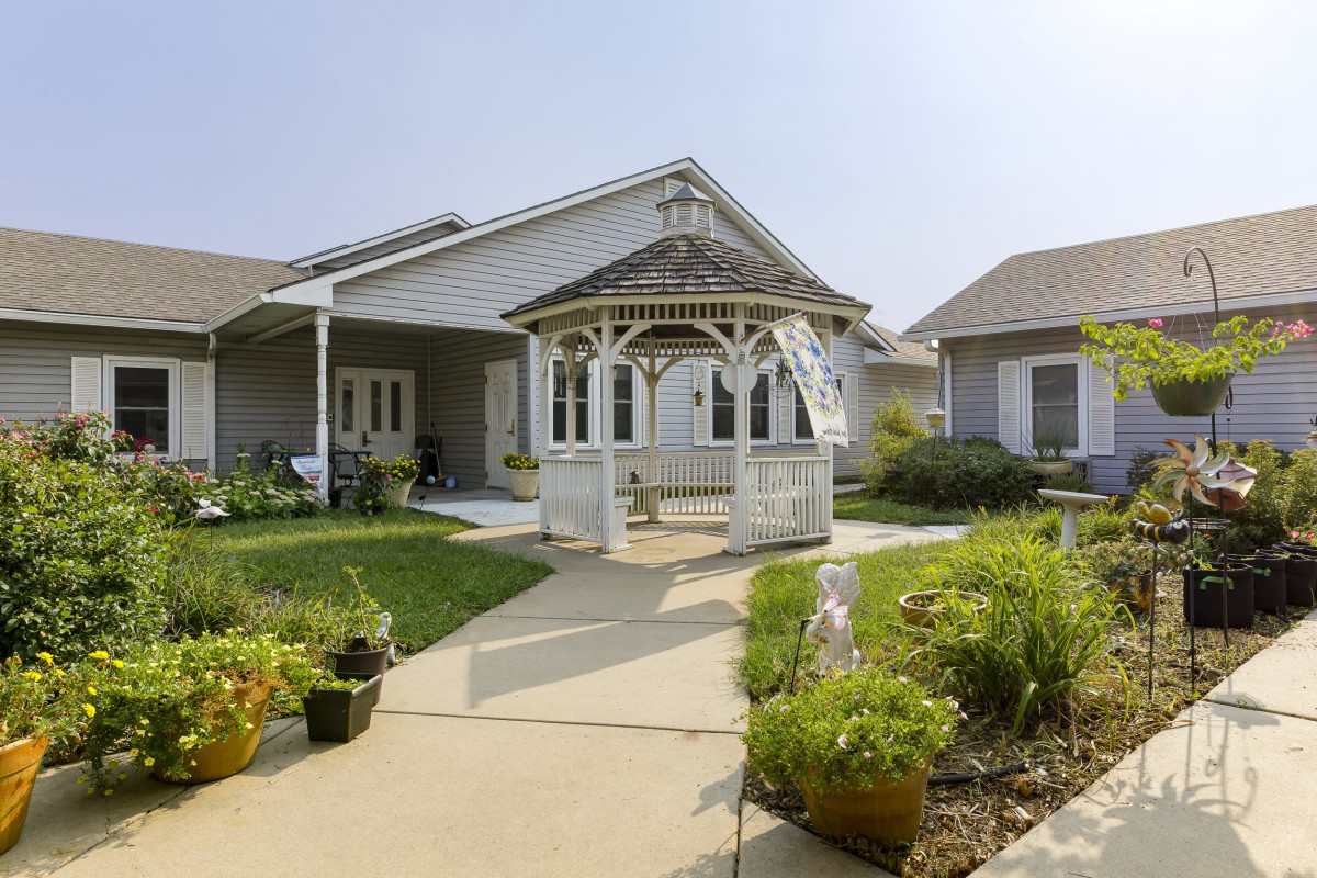 A charming suburban home with a gazebo and well-maintained garden.