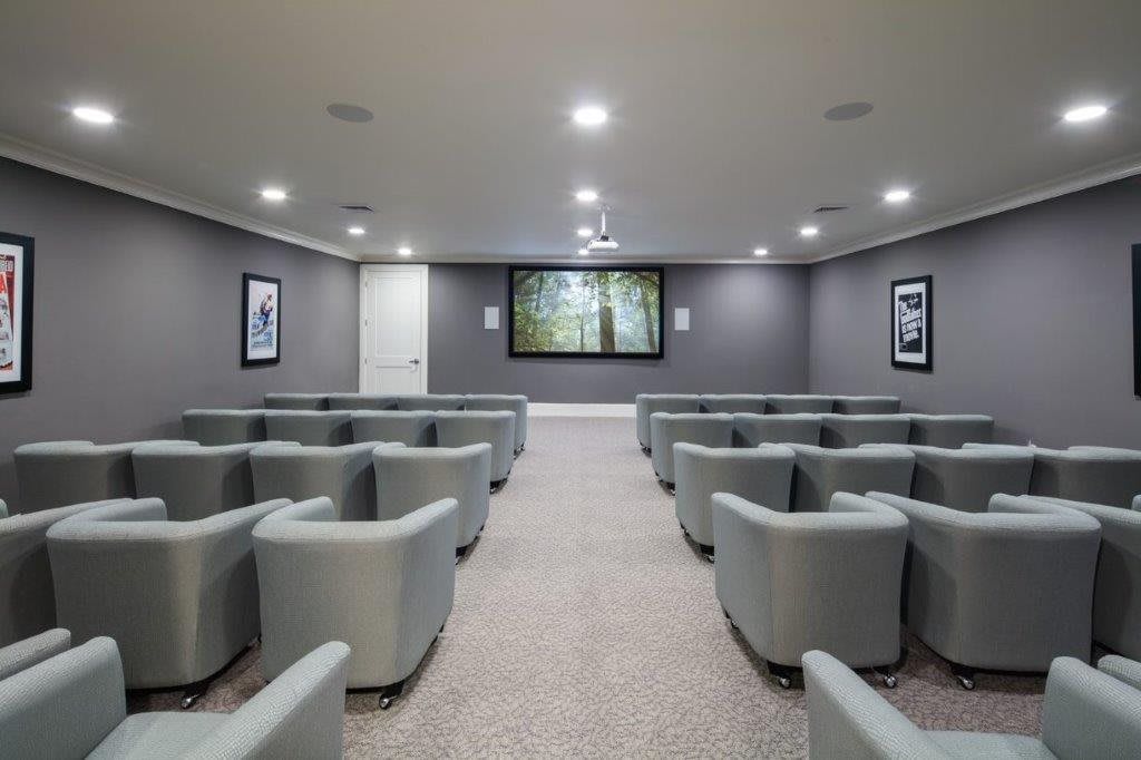 A spacious home theater with comfortable seating and a large screen.